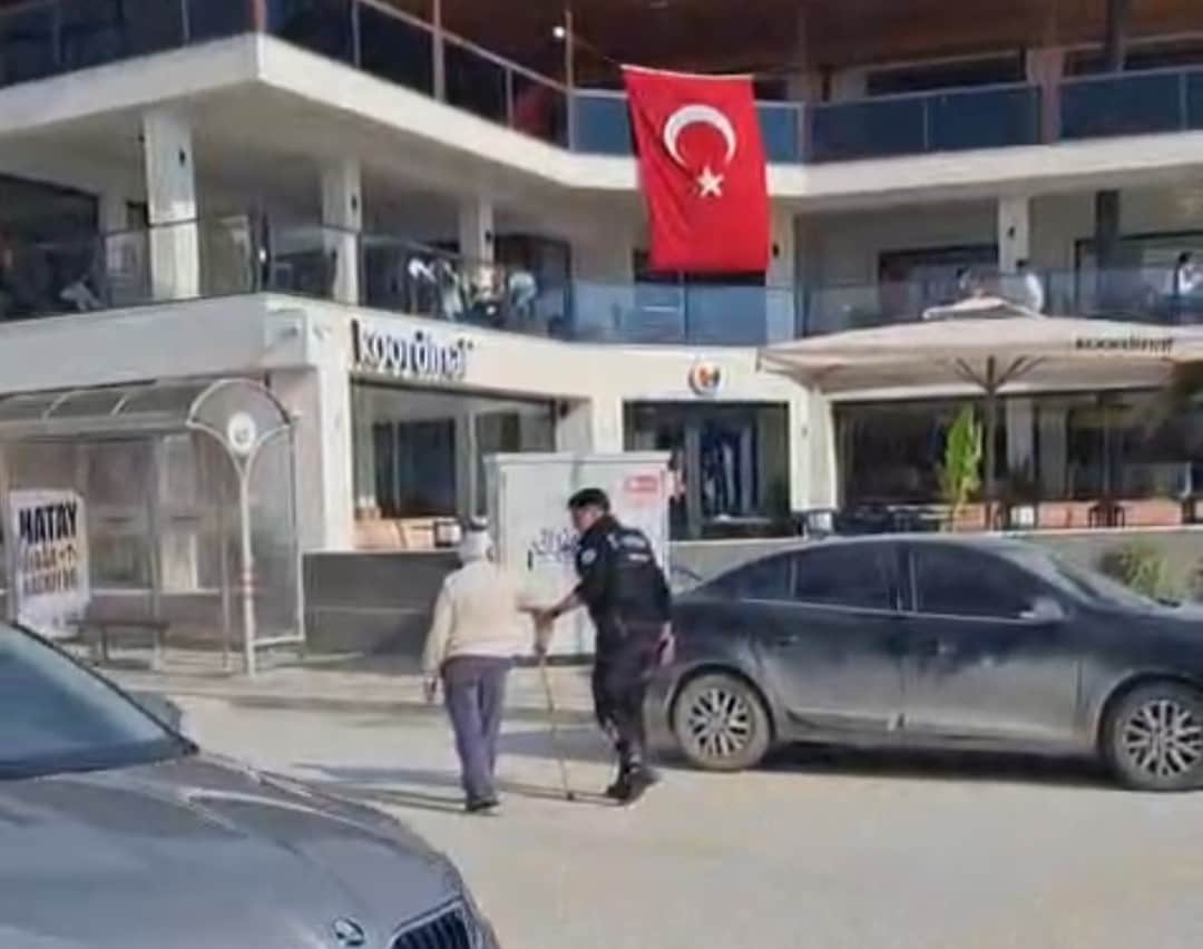 Hatay’da polisin, yolun karşısına geçmekte zorlanan kişiye yardım ettiği anlar kamerada