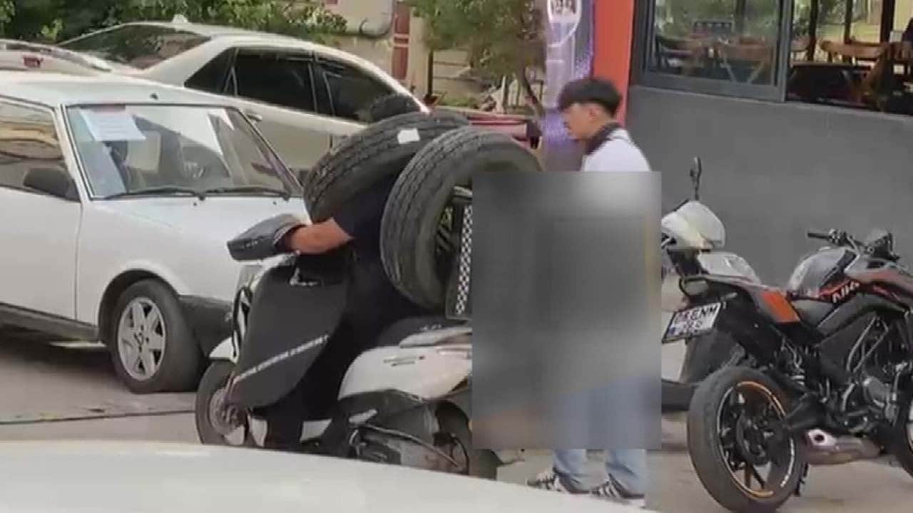 Kurye resmen kazaya davetiye çıkardı: Otomobil lastiğini boynuna asarak taşıdı
