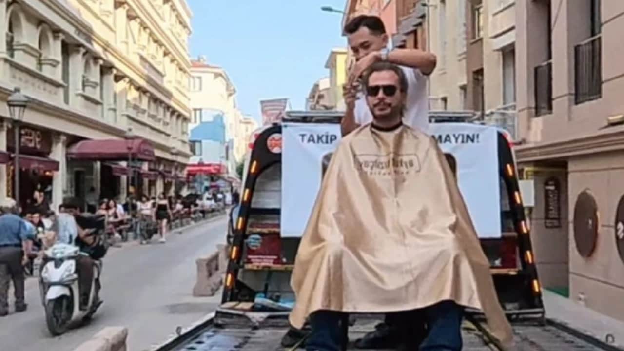 Kuaförden yürekleri ağızlara getiren şov: Yürüyen çekici üstünde saç traşı!