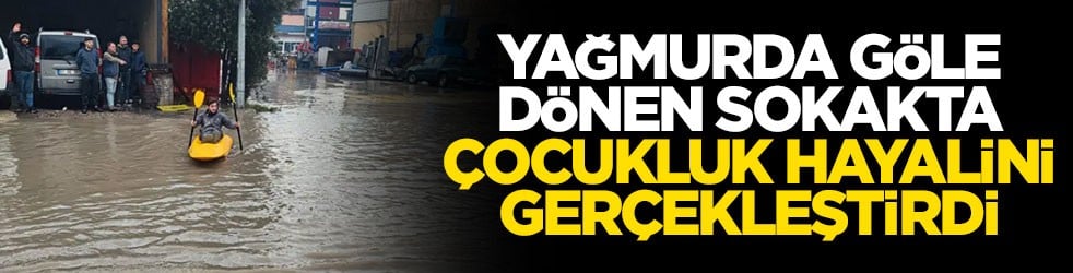 Yağmurda göle dönen sokakta çocukluk hayalini gerçekleştirdi