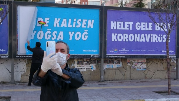 Foto - Asılan afişlerde, ‘Sen dinine imanına evde kal’, ‘Evde kalisen yoğsa yoğ’, ‘Nelet gele böyle korona virüse’, ‘Sen Allah’an eve git’ ve ‘Hani evde kalidin’ gibi ifadelere yer verildi. <br> Yöresel şiveli mesajlar görenleri gülümsetirken, bazı vatandaşlar ise asılan billboardların önünde özçekim yaptı.