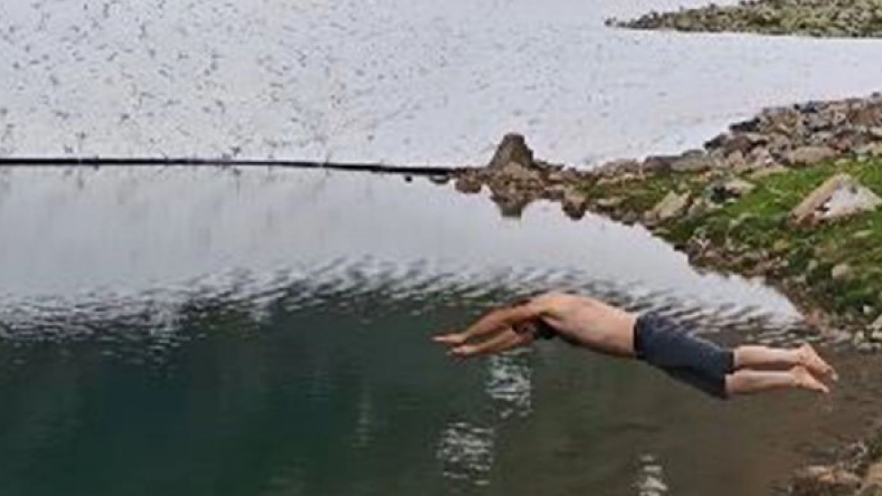 Yaz mı kış mı belli değil! Etrafı karla kaplı gölde yüzdüler