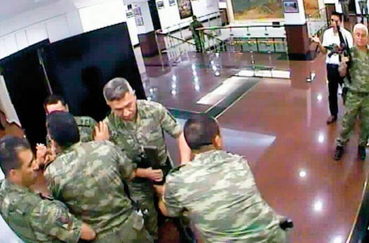 Org. Huduti’nin odasına girmeye çalışan bir albaya korumalar müdahale ediyor.