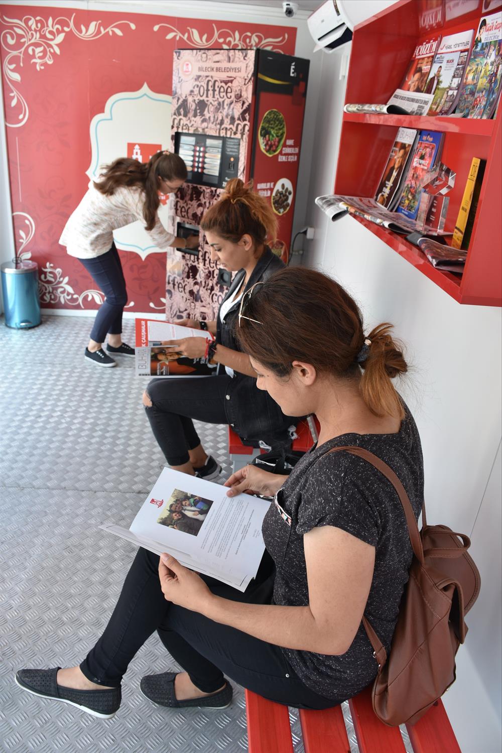 Otobüsü serin bir ortamda bekleyen vatandaşlar bir yandan kahve içerken diğer taraftan kitap okuyabiliyorlar.