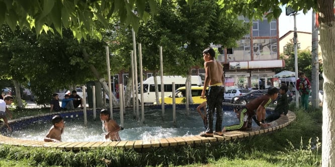 Çocuklar süs havuzunda serinliyor