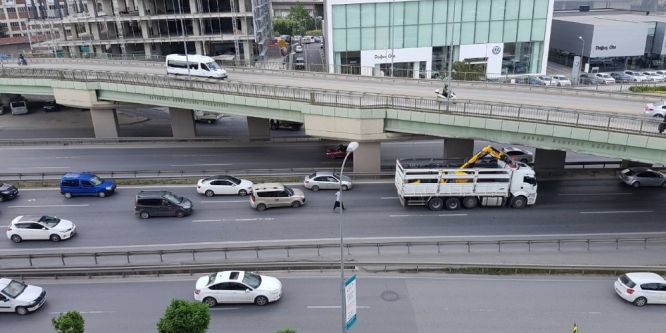 İş makinesi taşıyan kamyon köprüye takıldı
