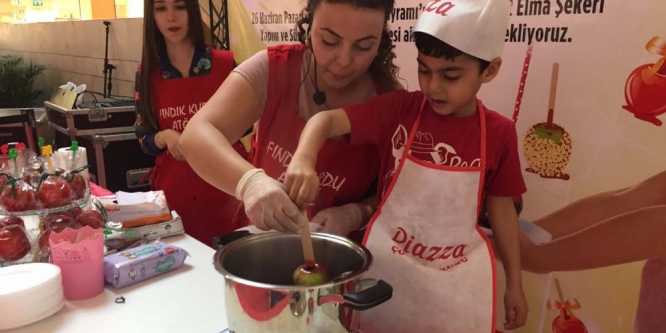 Minik eller elma şekeri süsledi