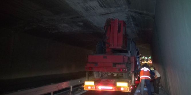 İş makinesi taşıyan TIR köprüye takıldı