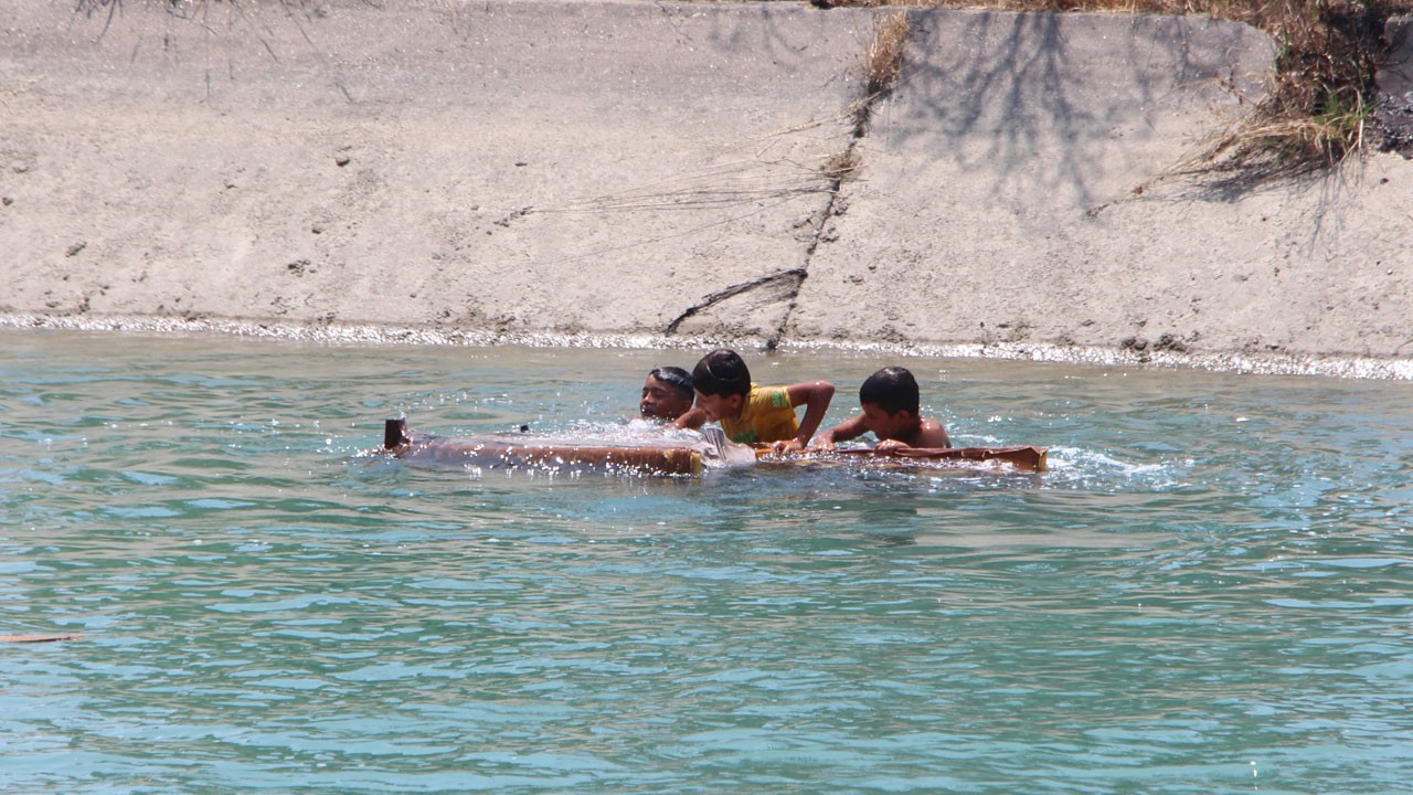 Adana’da akılalmaz manzara! Çocuklar koltukla kanalda sörf yaptı