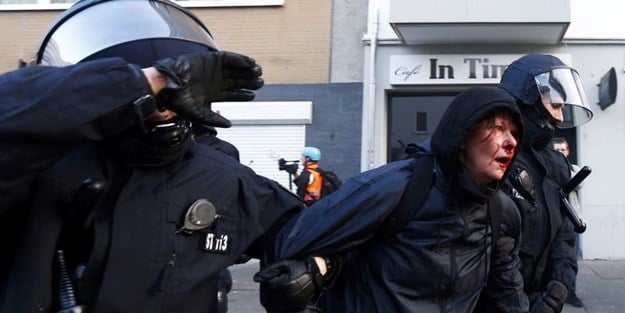 Alman polisi eylemci kadının yüzünü dağıttı!