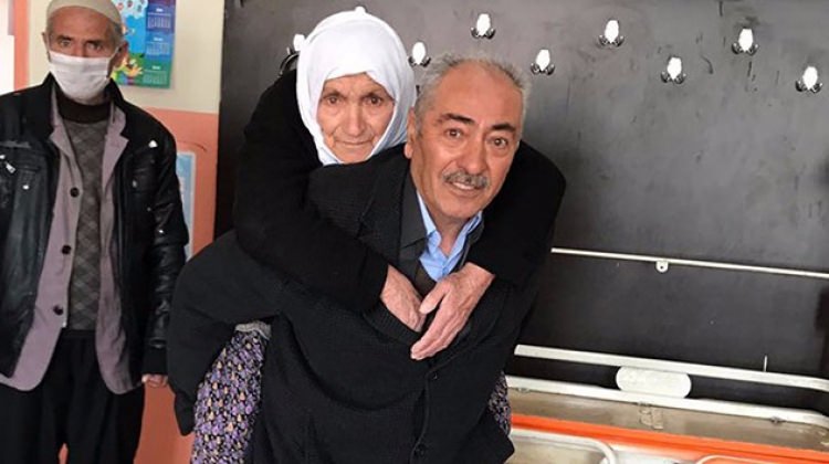 Annesini sırtında taşıyarak oy kullanmaya getirdi
