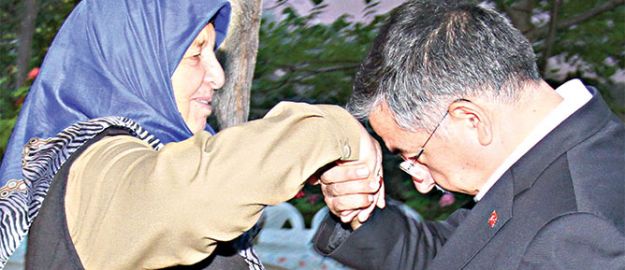 Bakan annesinin elini öptü