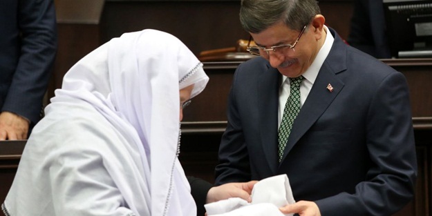 Davutoğlu'na sürpriz hediye, öpüp başına koydu