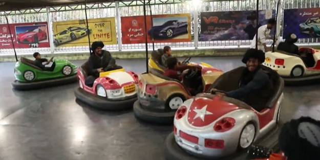 Batı'nın 'vahşi' gösterdiği Taliban üyeleri çocuklarla lunaparkta eğlendi!