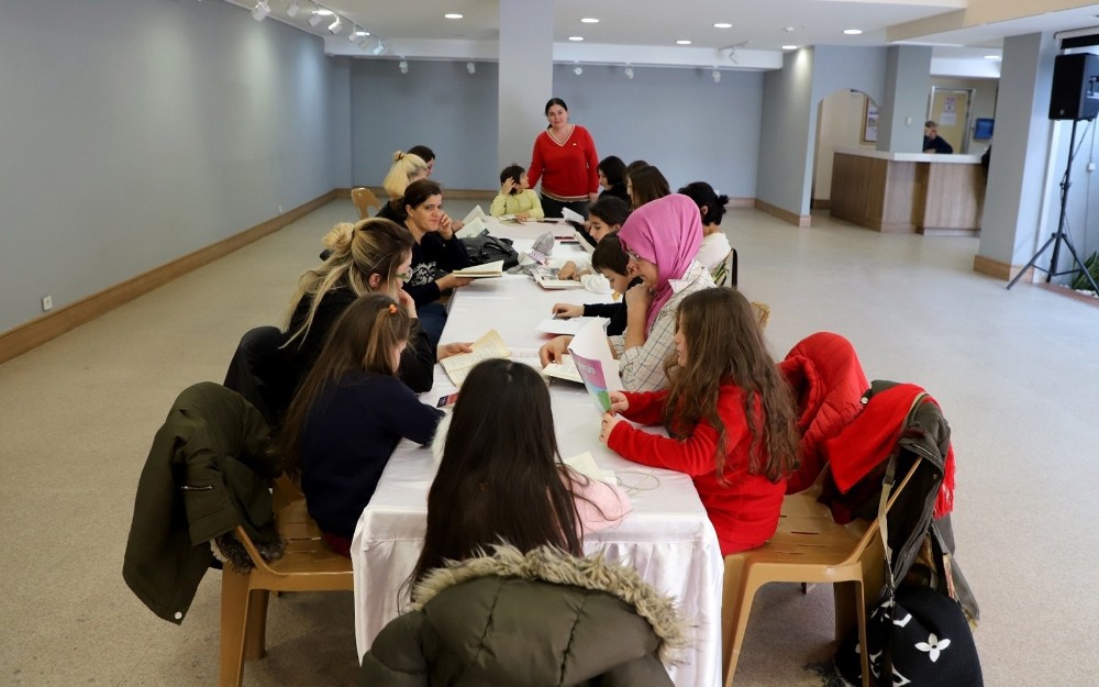 Büyükçekmeceli çocuklar anneleriyle birlikte kitap okuyor 