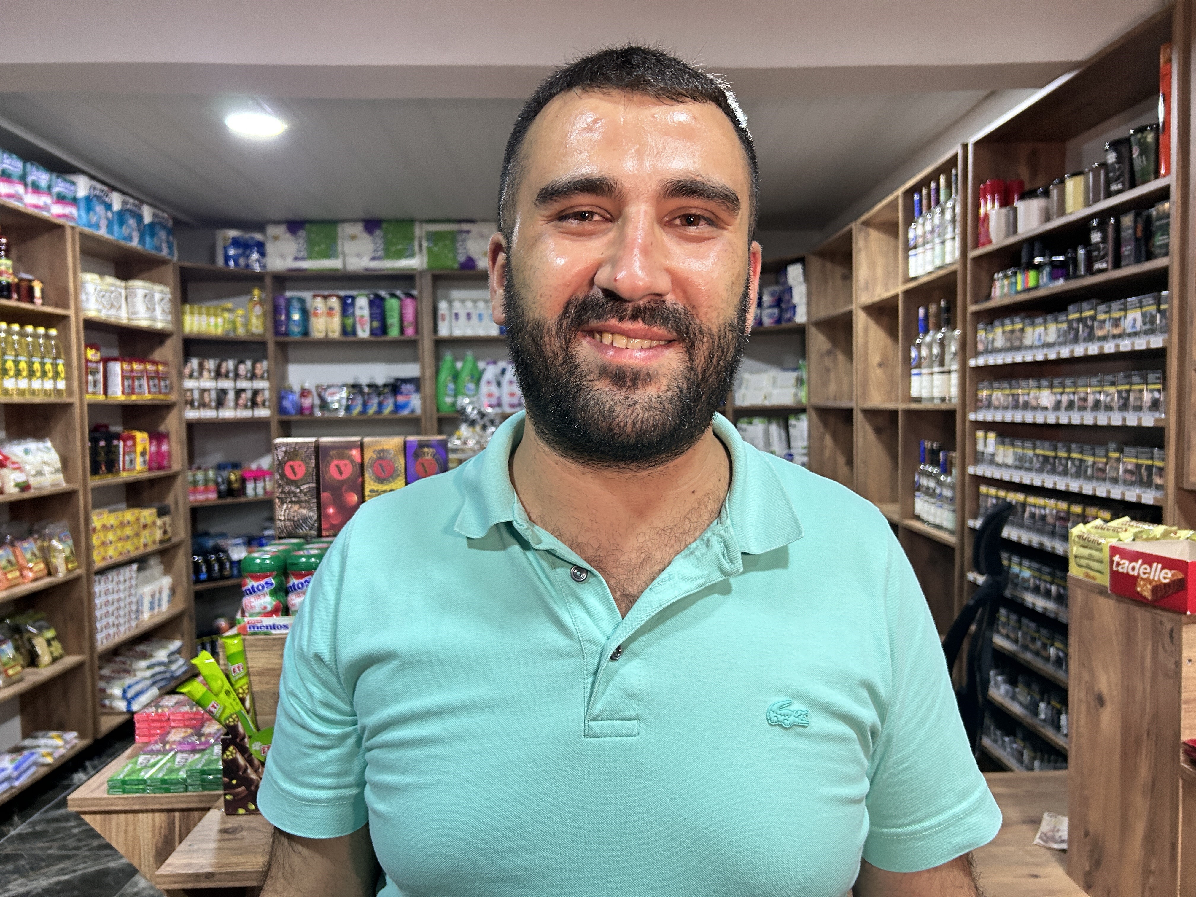 Çamur olan ayakkabısını çıkararak markete giren inşaat işçisi