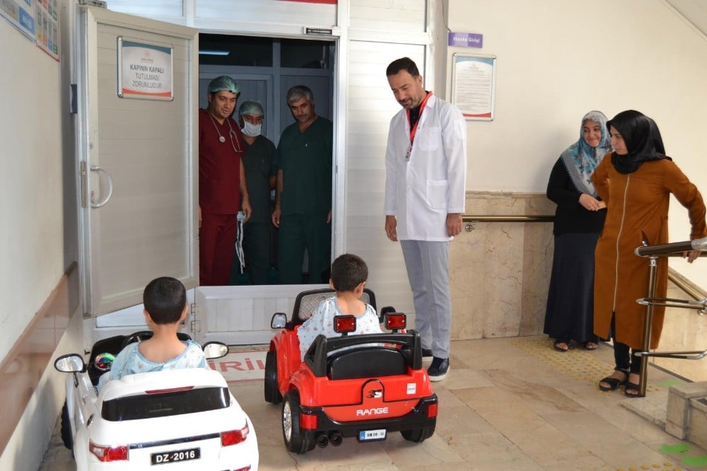 Çocuklar gülerek bindikleri akülü arabayla ameliyata giriyor 