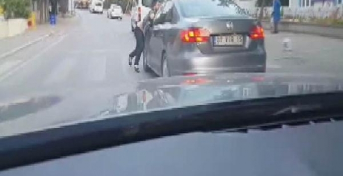 Durdurmak istediği sürücü gaza basınca kaputta asılı kaldı