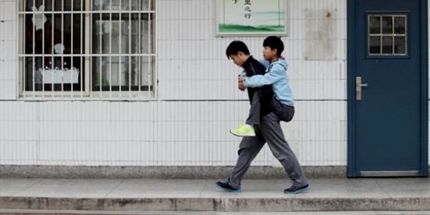 Engelli arkadaşını her gün sırtında taşıyor