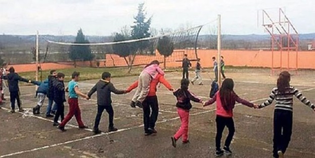 Engelli öğrencisini sırtında taşıyor