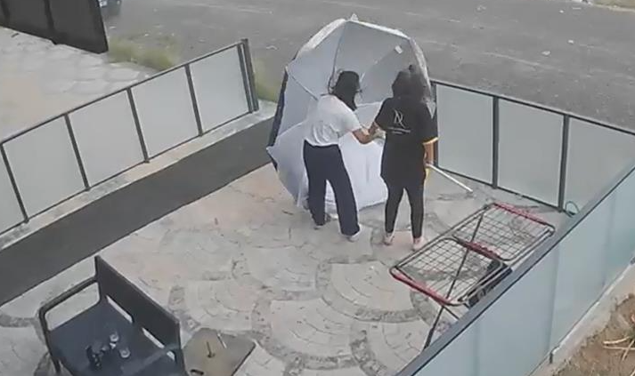 Fırtınada genç kızın zor anları: Şemsiye onu sağa sola savurdu