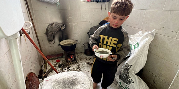 Gazze'de yürek yakan görüntü! Tuvalette yemek pişirip çocuklarına yediriyorlar