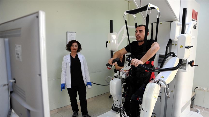 Gribin tetiklediği sendromla felç geçirdi, robotla yürümeye çalışıyor