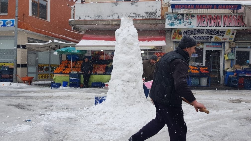 Hem dükkanlarının önünü temizlediler hem de kardan adam yaptılar 