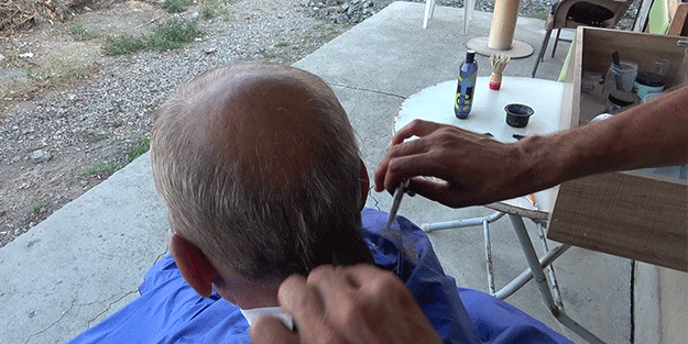 İş yeri yıkılan depremzede berber evinin önünde işine devam ediyor