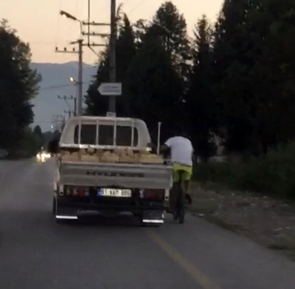 Kamyonete takılan bisikletli görenleri şaşkına çevirdi 