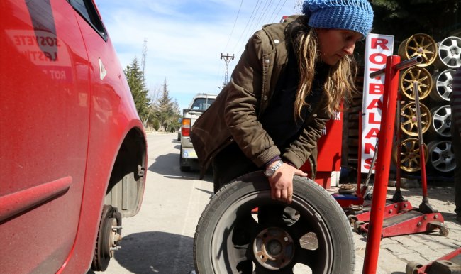 Kocasının yanında lastik tamir ediyor