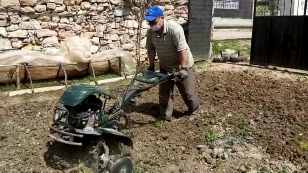Köy imamı, evden çıkamayan yaşlı adamın bahçesini sürdü 