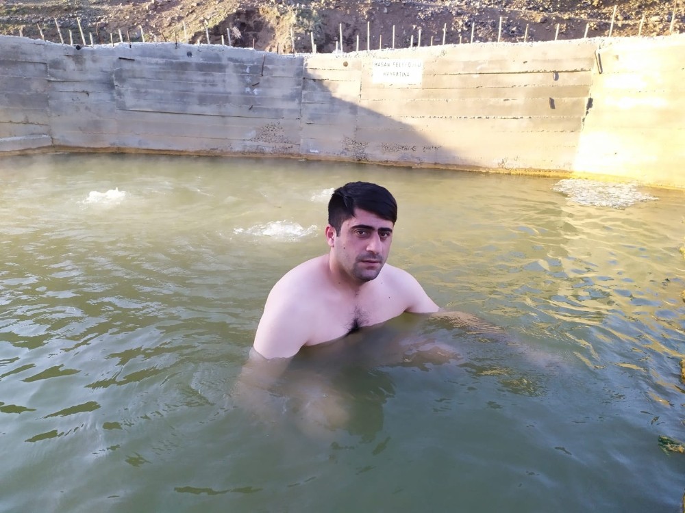 Köyüne dönen genç adam, jeotermal suya girerek kendini koruyor 