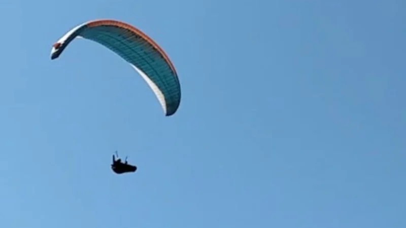 Mahallenin üstünden geçen paraşütçüyü çaya çağırdı