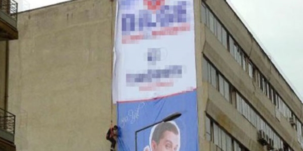 Metrelerce yüksekliğe iple asılarak afiş astı