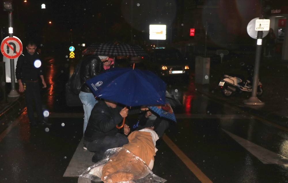 Motosikletten düşen kadını şemsiyelerle yağmurdan korudular 