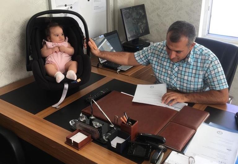 Okul müdürü çocuğa bakıyor, öğretmen de öğrencilere ders veriyor 