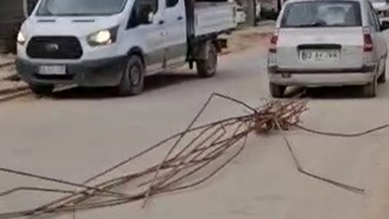 Otomobilin arkasına bağladığı demirlerle trafikte ilerledi