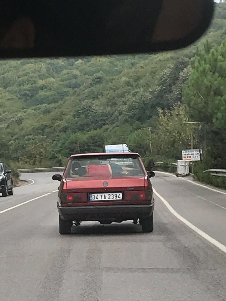 (Özel) Otomobilin arka camıyla koltuğu arasında uyuyan çocuğun tehlikeli yolculuğu kamerada 