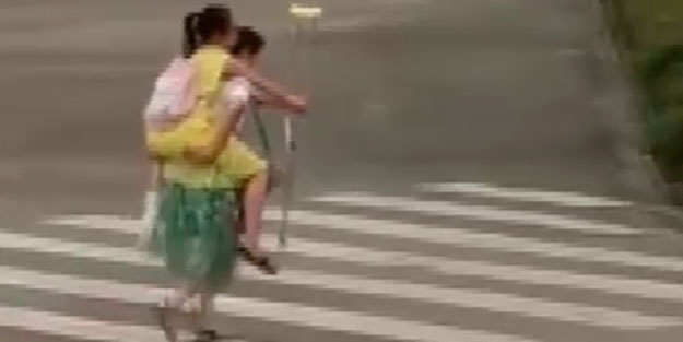 Paylaşım rekorları kıran video! Koltuk değnekli kızı sırtında taşıyarak yoldan geçirdi