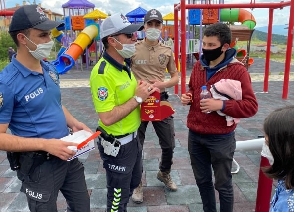Polis, parklarda oynayan çocuklara çikolata kek ve meyve suyu ikram etti 