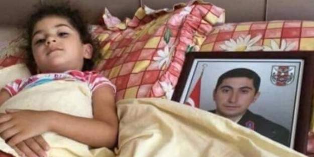 Şehidin kızı babasının fotoğrafıyla yatıyor