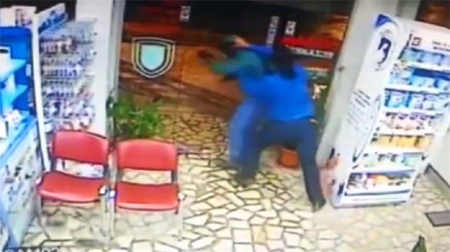 Silahlı soyguncuyu yaka paça dışarı attı