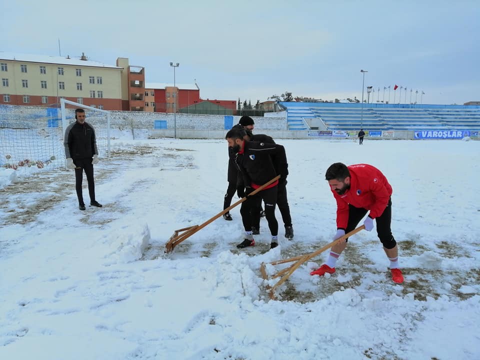 Sporcular çim sahada kar küredi 