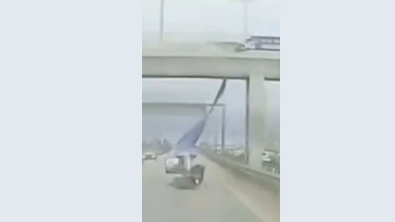 Sürücü yola savruldu! Üst geçitten sarkan afiş motosikletliye çarptı