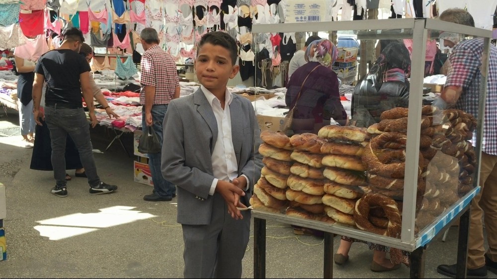 Takım elbisesiyle tezgah başına geçip, okul harçlığı için simit satıyor 