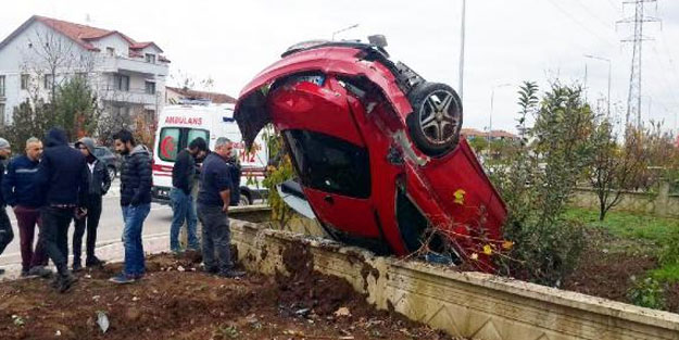 Takla atan otomobil, bahçe duvarının üzerinde ters durdu
