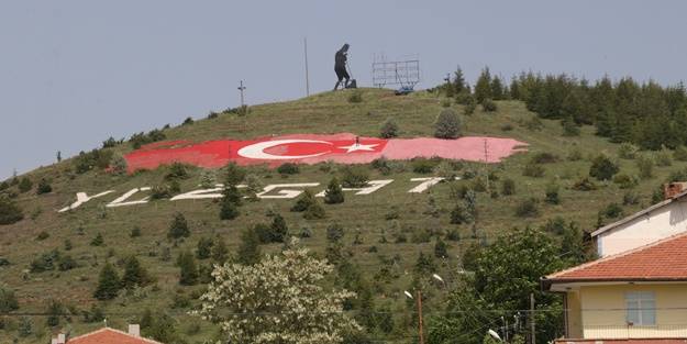 Tepenin yamacındaki rengi solan dev Türk bayrağını boyuyor