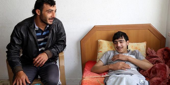 Bombardıman sonucu felç olan gence ağabeyi bakıyor