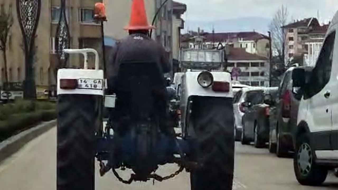 Trafikte şoke eden manzara! Başına trafik dubası geçiren traktör sürücüsü herkesi kahkahaya boğdu!